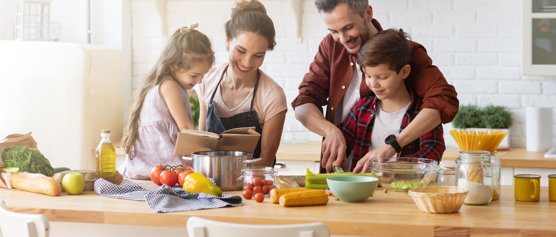 Famille heureuse préparant un repas, coupant des légumes sur le comptoir de la cuisine